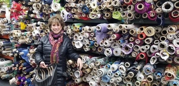 Sally with many yards of cloth in rolls