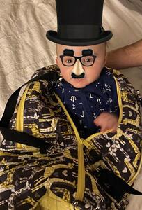 baby in groucho disguise inside a duffel bag